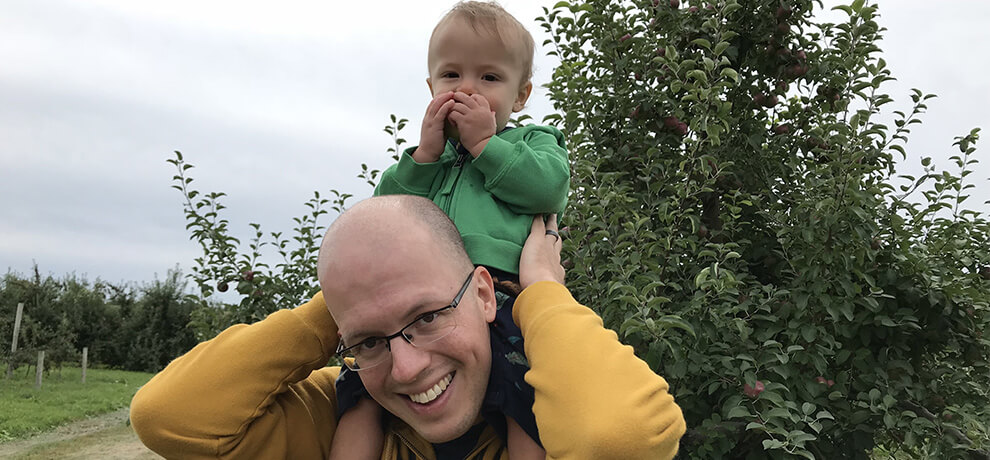 tom with his son felix at an apple orchard