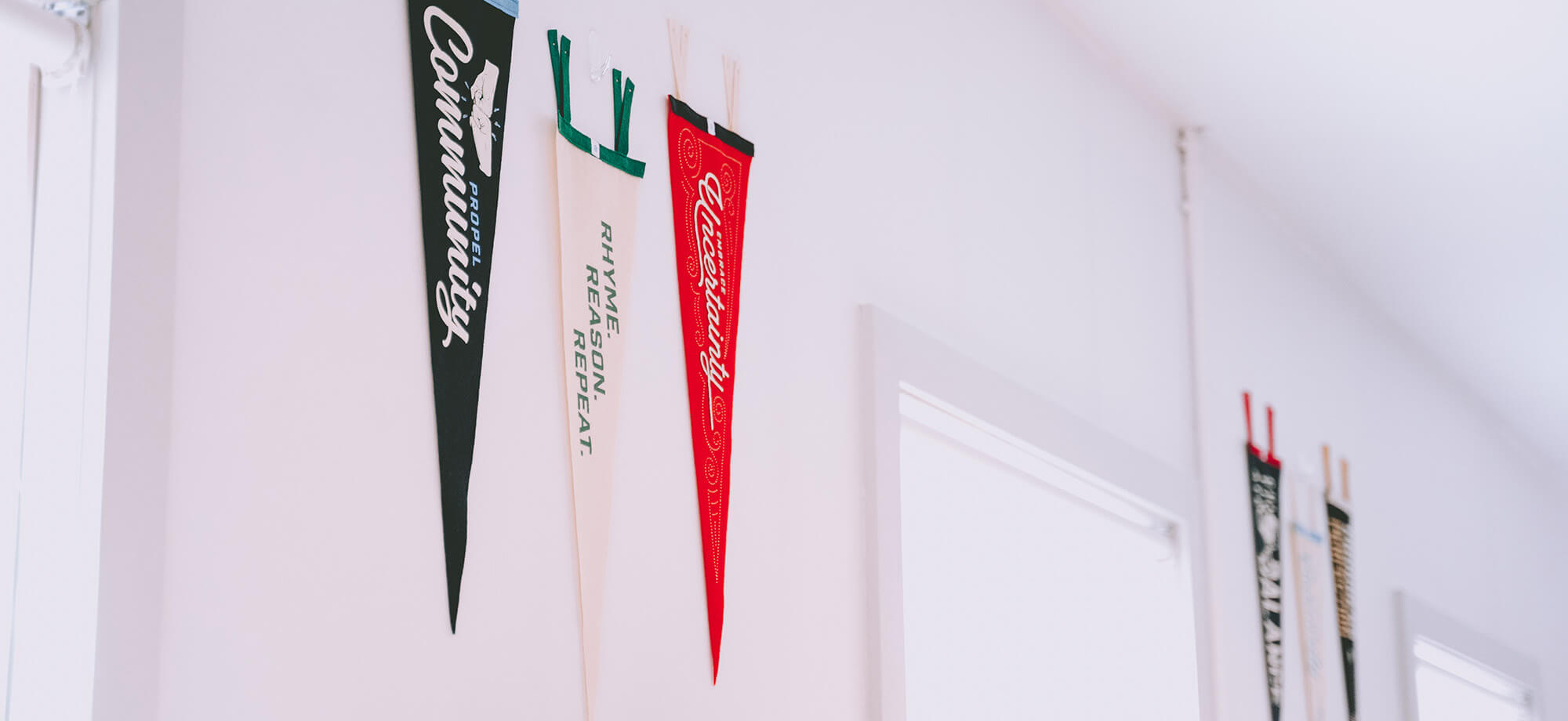 six pennants hanging on a white wall
