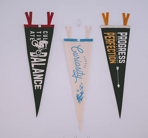 three pennants hanging on a white wall