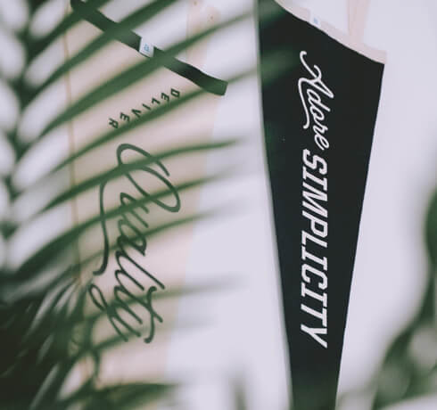 a close-up of two studio pennants: deliver quality and adore simplicity