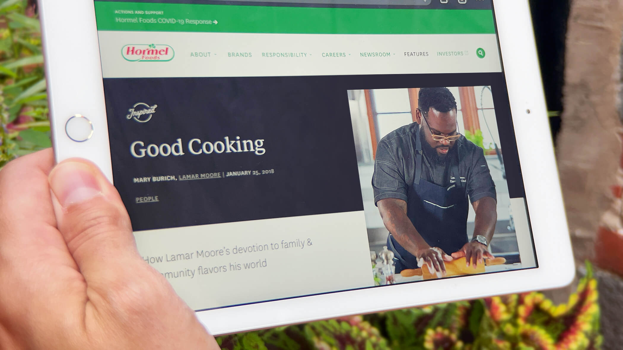 a hand holding an ipad with a cooking story from hormelfoods.com on it