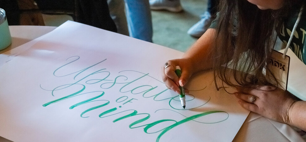 woman creating a hand written poster at Create Upsate conference